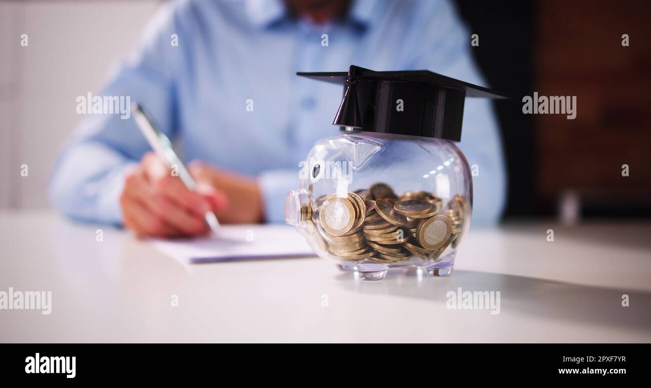 Piggy Bank con bilancio scolastico. Prestito laureato Foto Stock