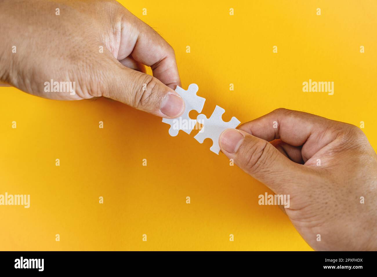 Abbinamento perfetto. Due mani che tiene pezzi di puzzle corrispondenti. Foto Stock