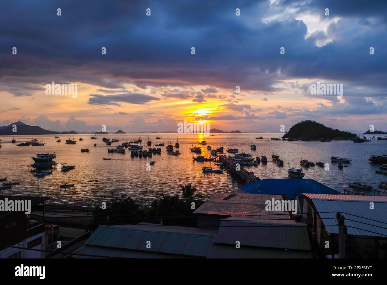 L'atmosfera del tramonto intorno alle acque e il Porto di Labuan Bajo, una delle destinazioni più importanti in Indonesia. Molte navi di vario tipo sono parcheggiate un Foto Stock