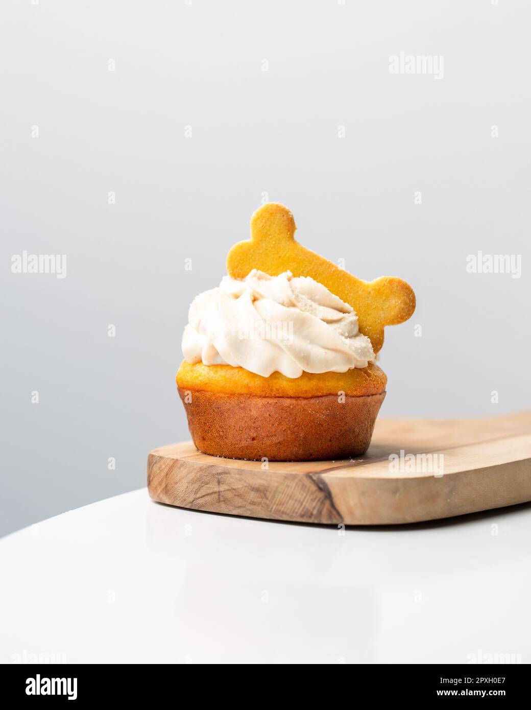 Un delizioso muffin appena sfornato sormontato da una bambola di soffice panna montata, pronta per essere gustata Foto Stock