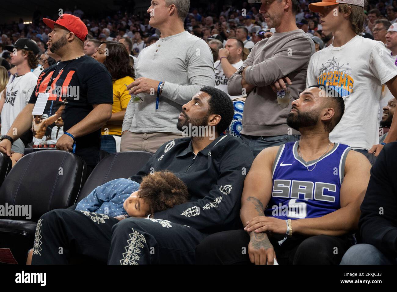 NBA player Kyrie Irving watches at courtside with his daughter Azurie Elizabeth Irving during the second half of Game 7 of an NBA basketball first-round playoff series between the Sacramento Kings and Golden State Warriors on Sunday, April 30, 2023, in Sacramento, Calif. The Warriors won 120-100. (AP Photo/José Luis Villegas) Foto Stock