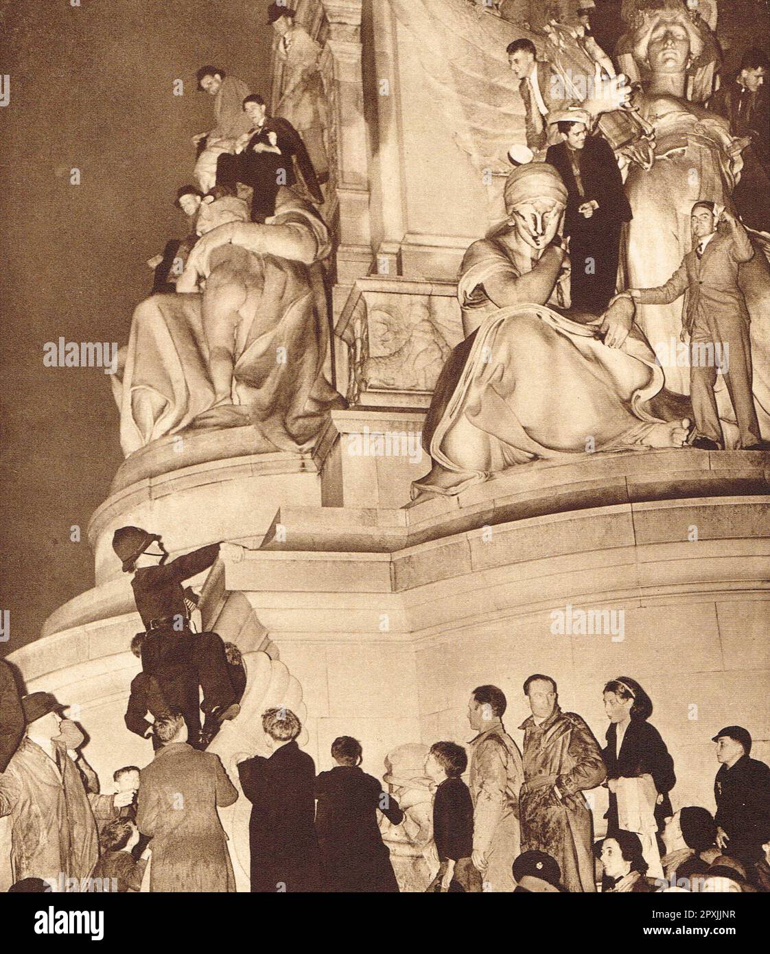 I membri del pubblico si sono recati sul memoriale di Victoria nella notte dell'incoronazione di re Giorgio VI, 12 maggio 1937. un poliziotto sta salendo per farli scendere Foto Stock