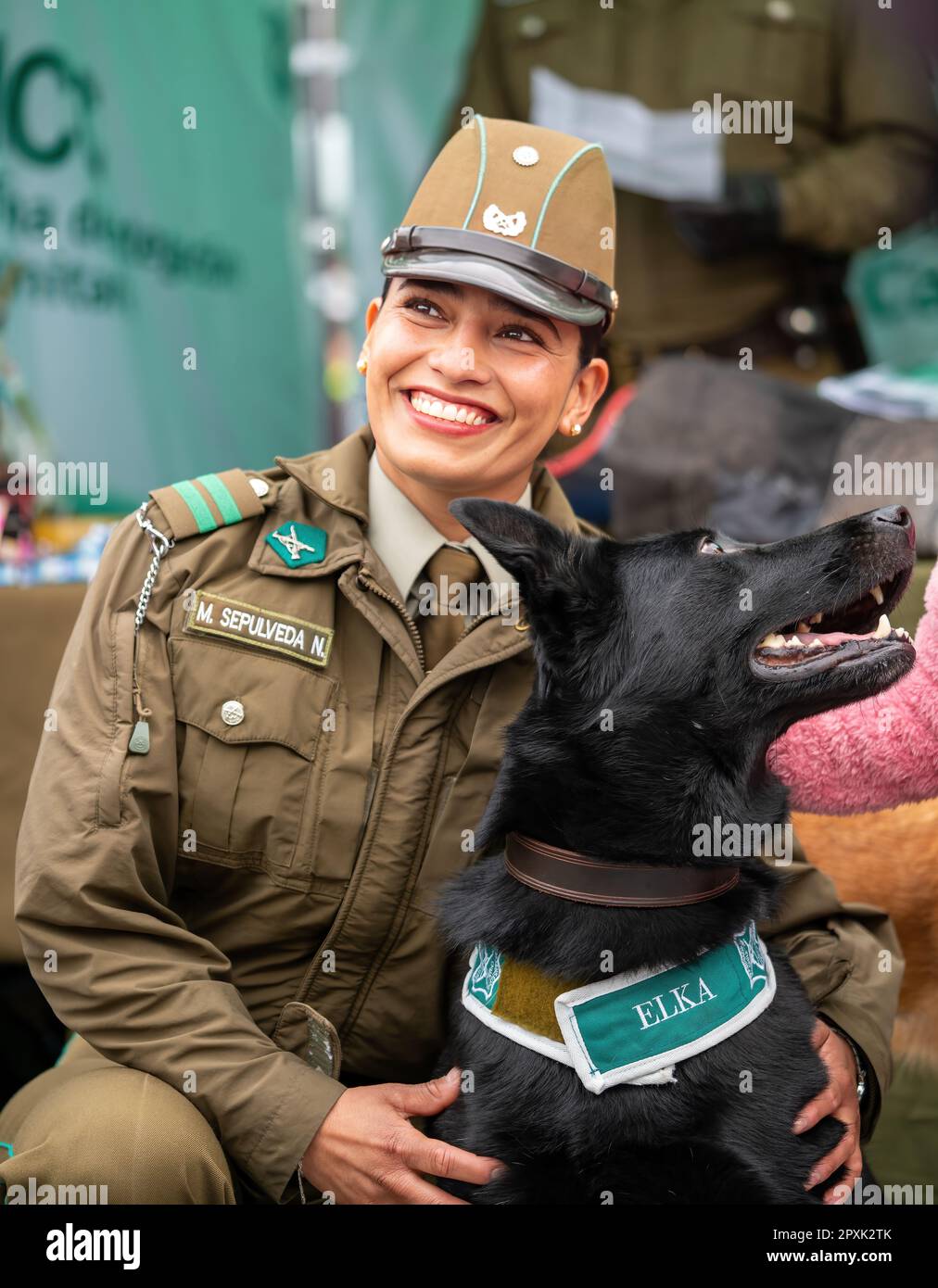 Una donna di servizio in uniforme con un compagno canino che si posa per una foto Foto Stock
