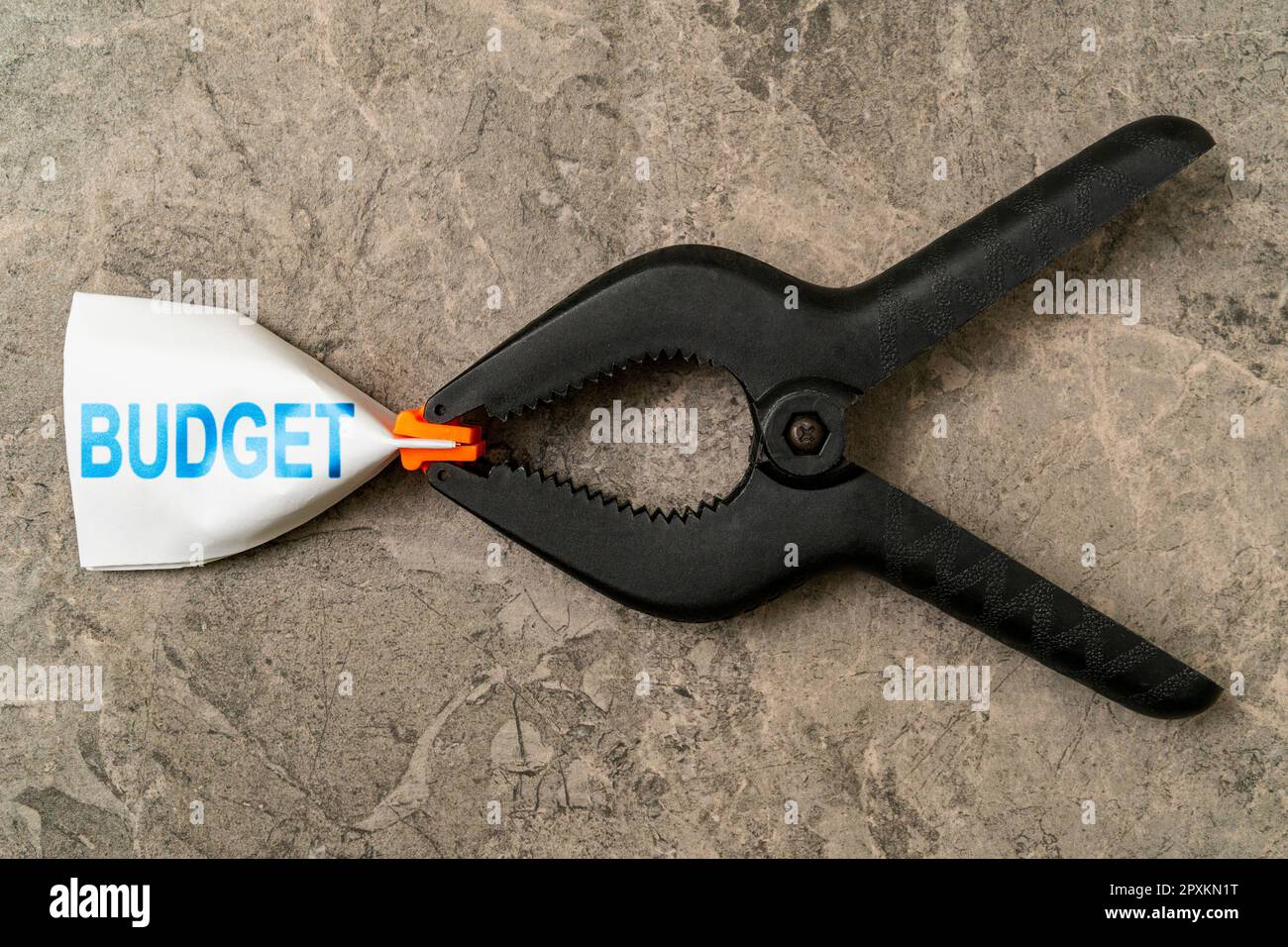 Budget inasprito in un morsetto. Inflazione, economia o crisi finanziaria, concetto di guerra commerciale. Il tasso di inflazione è l'aumento di prezzo del servizio e dei beni in A. Foto Stock