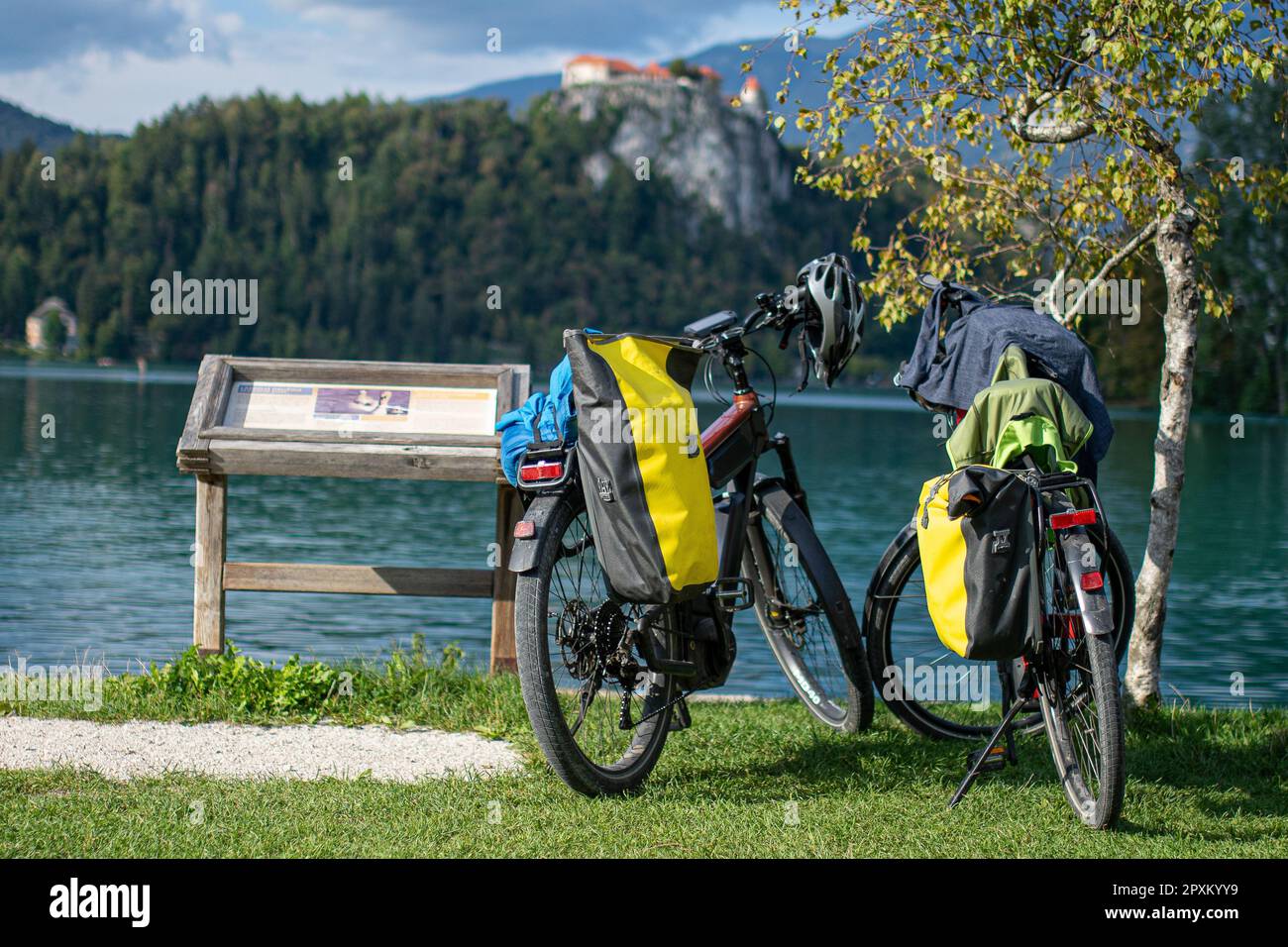 due biciclette con panniere parcheggiate sulla riva del lago hanno sanguinato la slovenia Foto Stock