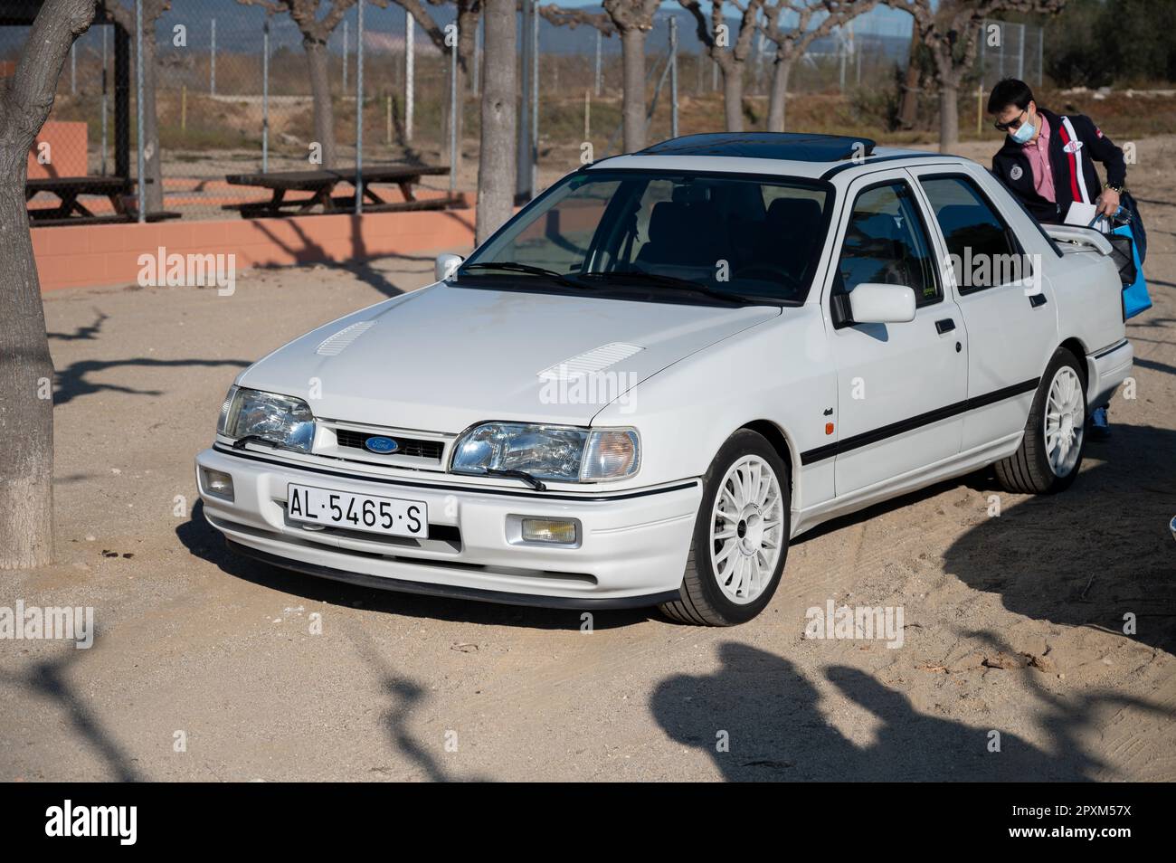 Particolare di una bella Ford Sierra Cosworth bianca. Il proprietario sta prendendo le cose dal bagagliaio Foto Stock