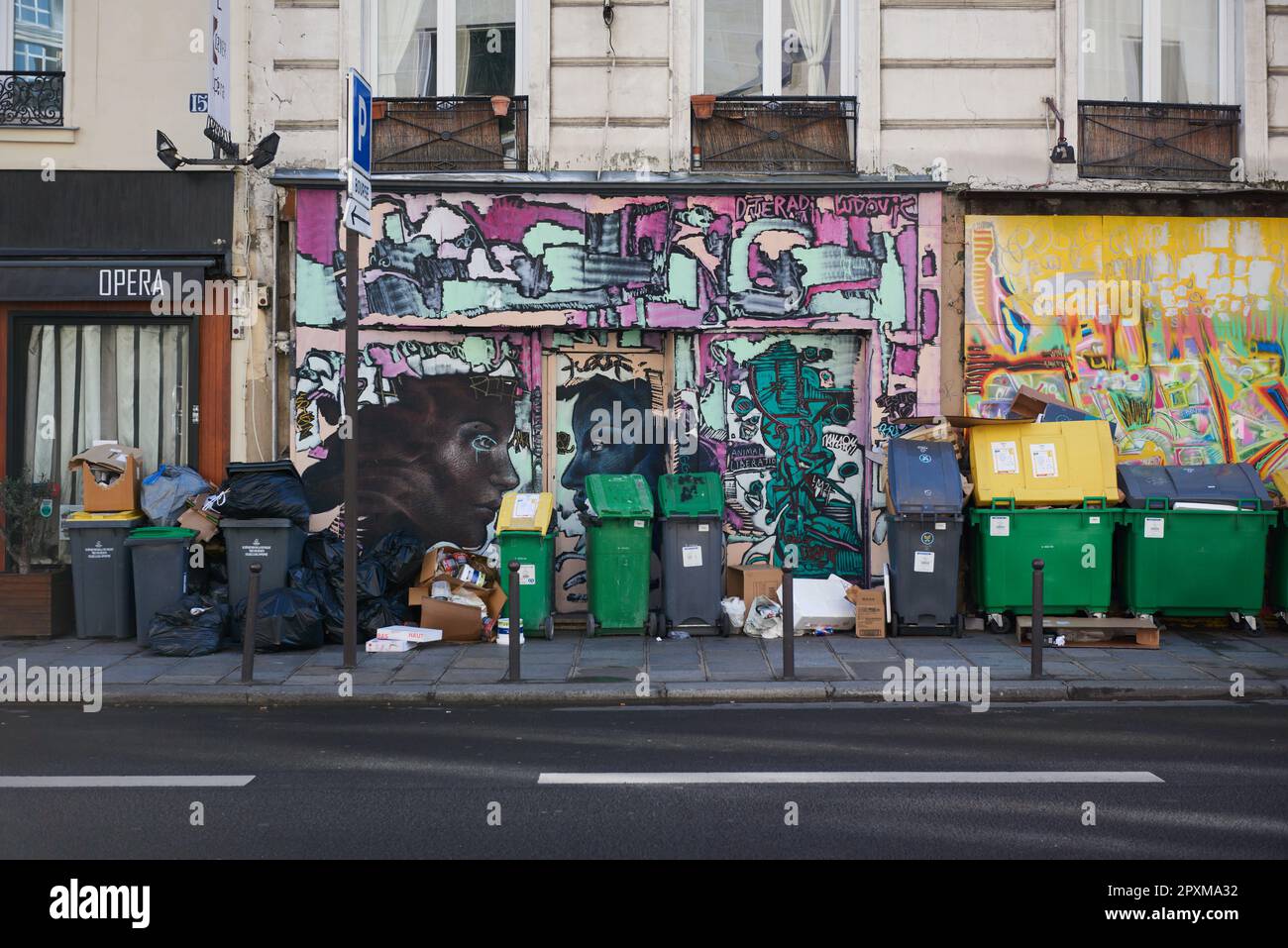 I rifiuti sono accatastati a Parigi davanti ai graffiti Foto Stock