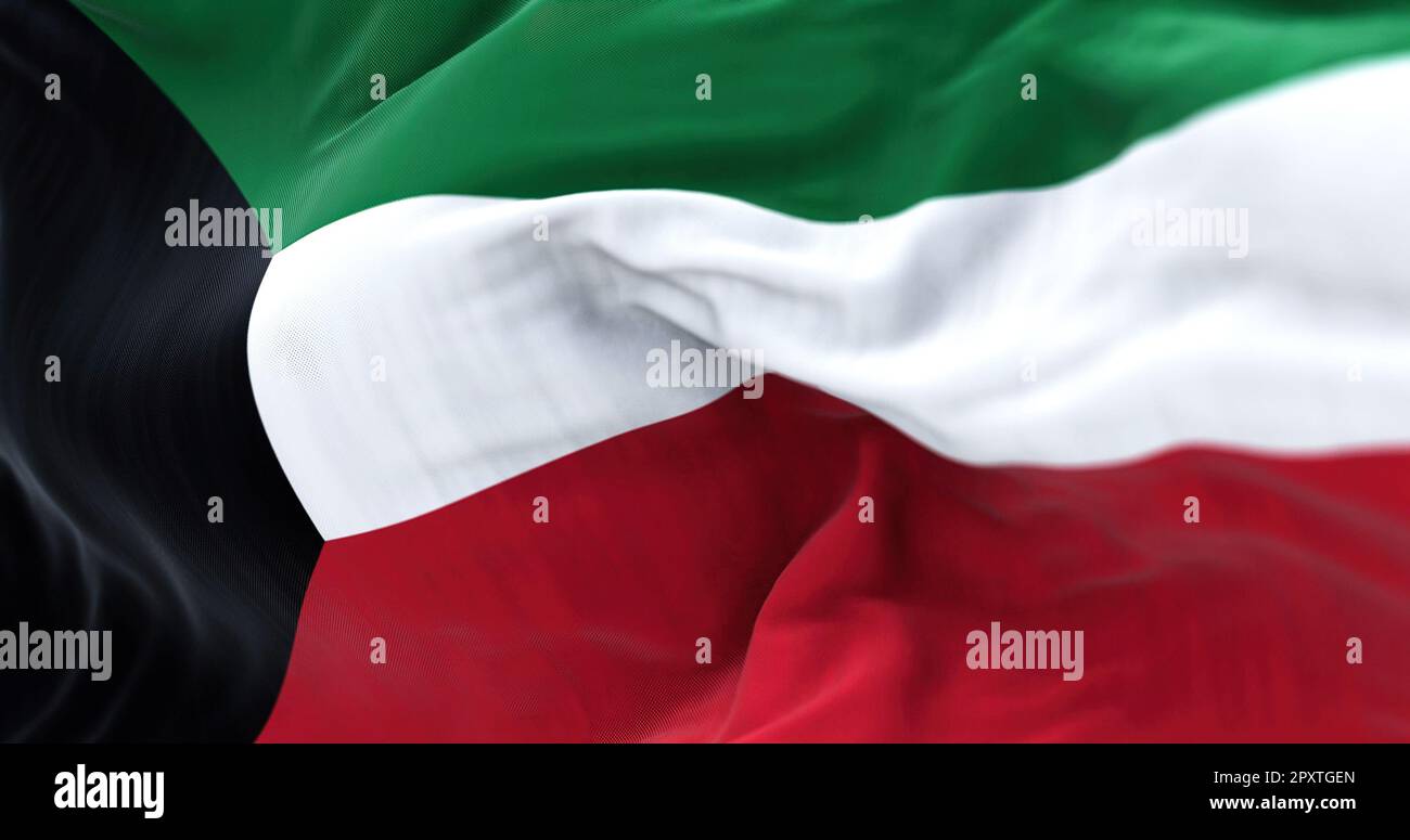 Vista ravvicinata della bandiera nazionale del Kuwait che sventola nel vento. Lo Stato del Kuwait è un paese dell'Asia occidentale. Tessuto ondulato. Sfondo strutturato. R Foto Stock