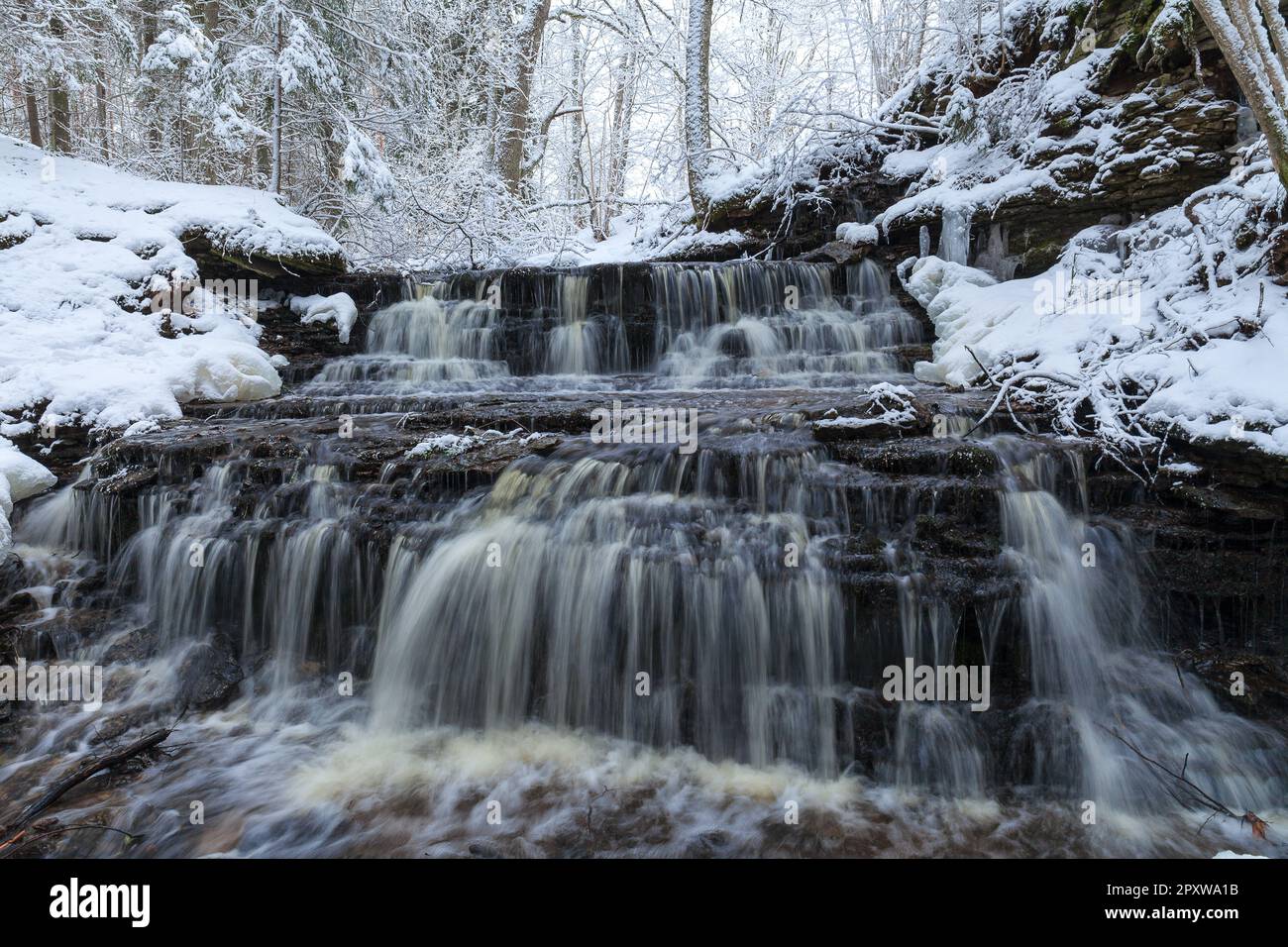 Piccola cascata Vasaristi in inverno, parco nazionale di Lahemaa, Estonia. Esposizione lunga Foto Stock
