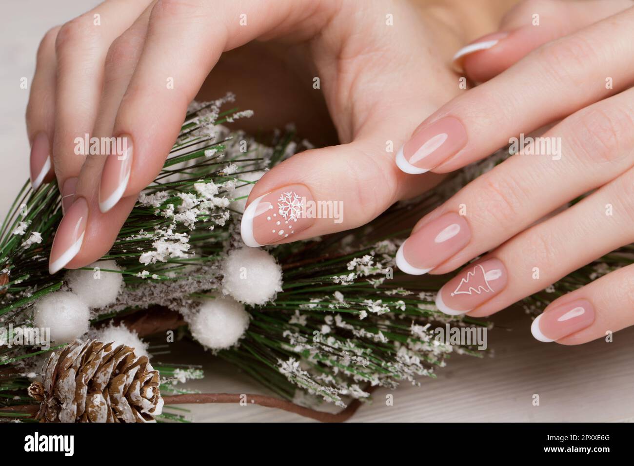 Manicure bianco neve sulle mani femminili. Design delle unghie invernali. Foto scattata in studio su uno sfondo di lana. Foto Stock