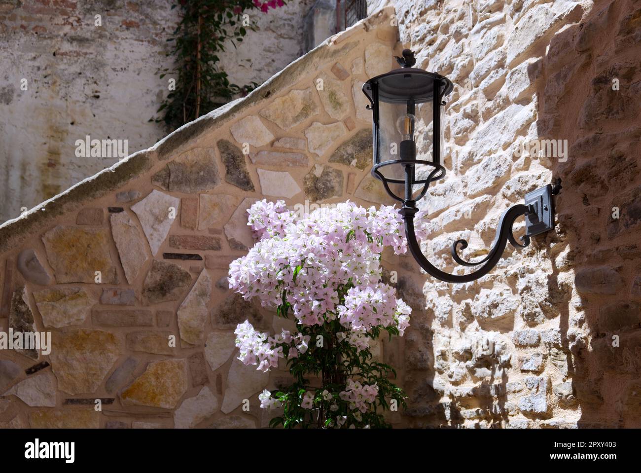 Una lanterna in ferro battuto su un muro di pietra in una casa colonica italiana Foto Stock