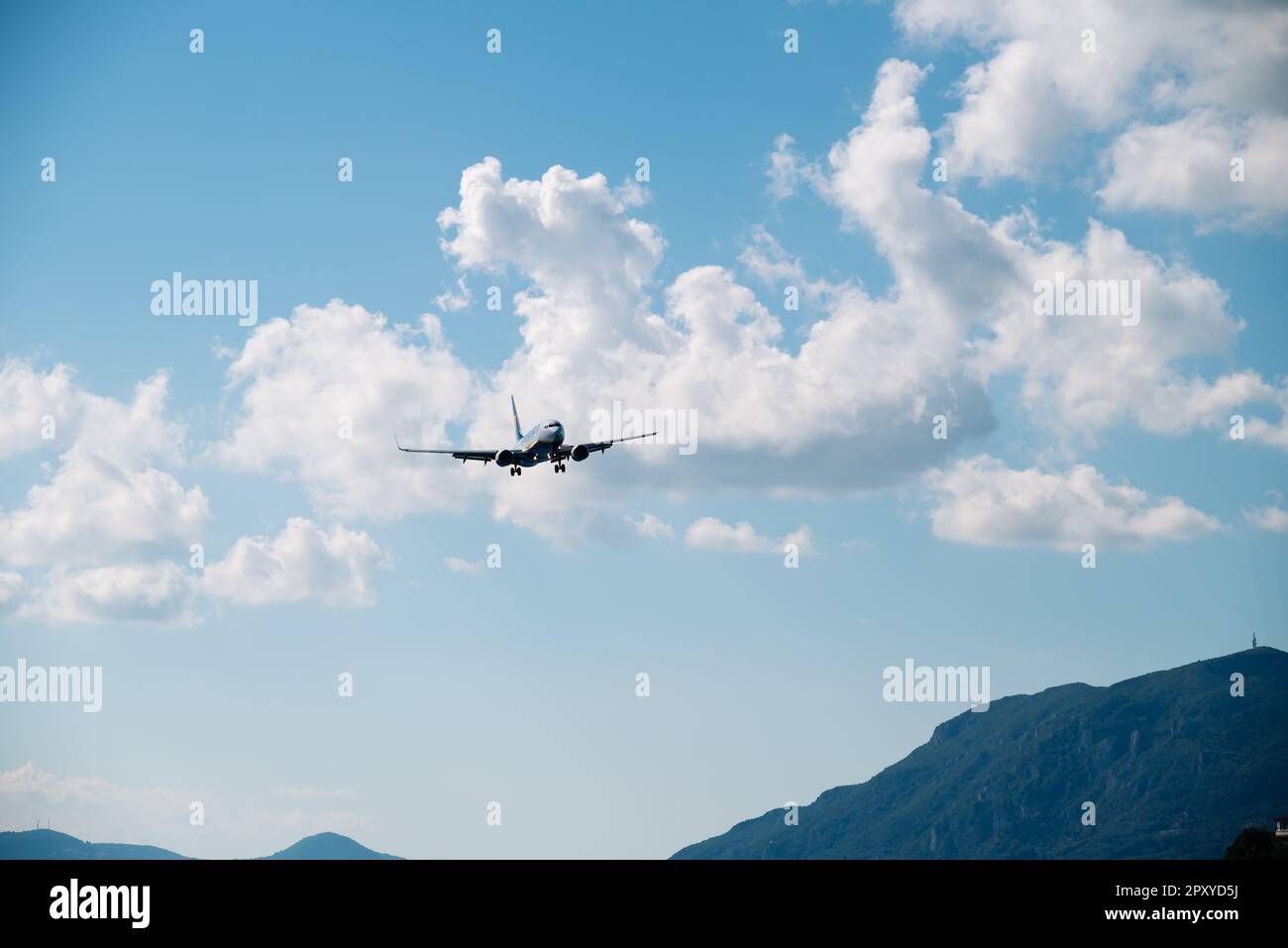Kerkyra, Grecia - 09 24 2022: L'aereo Ryanair sta atterrando sullo sfondo del cielo blu e delle montagne. Il concetto di atterraggio di emergenza e tecnico Foto Stock
