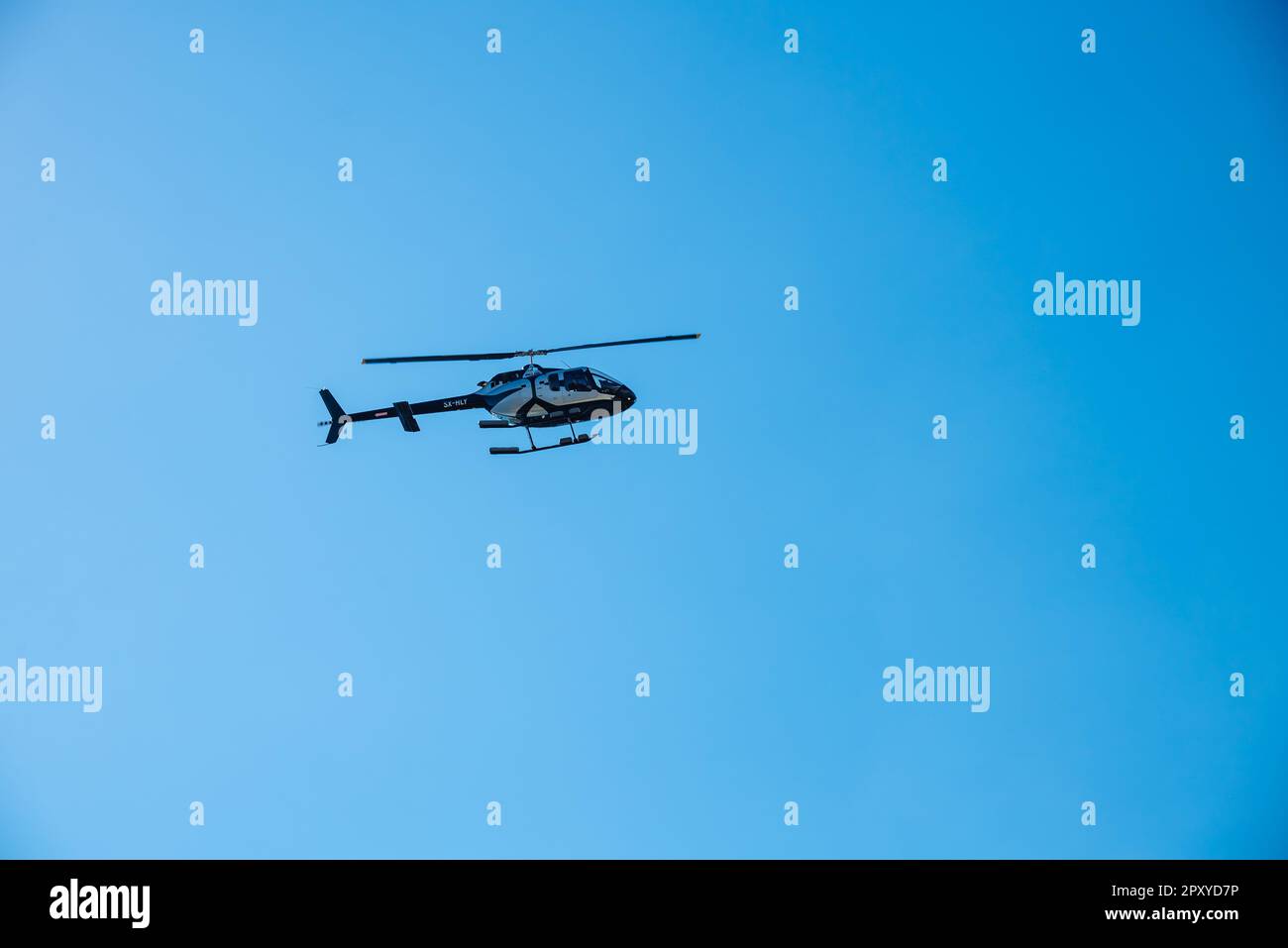 Kerkyra, Grecia - 09 24 2022: Elicottero bianco e nero atterra all'aeroporto di Corfù. Il concetto di controllo di un veicolo aereo con Landin verticale. Foto Stock