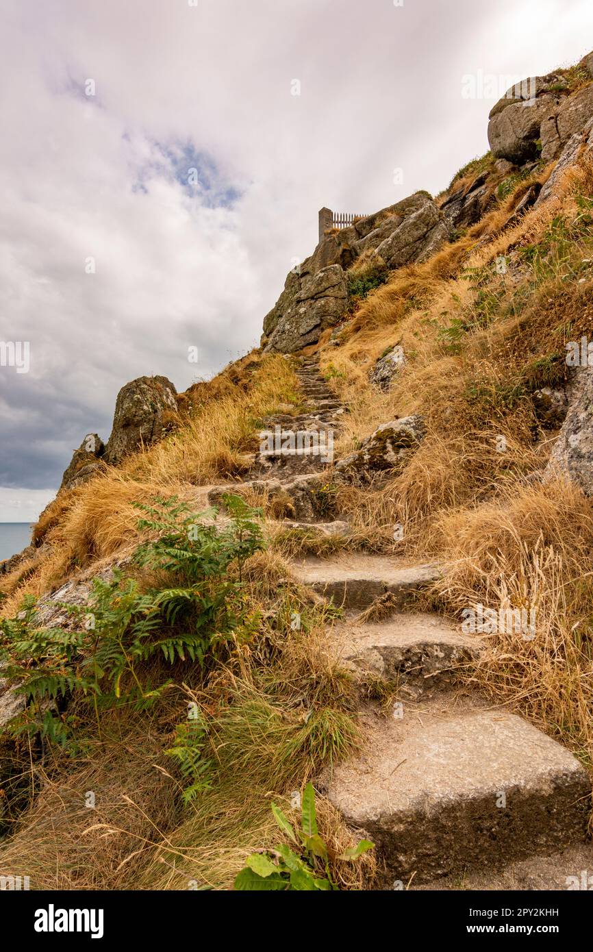 Ripidi e stretti gradini del South West Coast Path che sale da Portcurno Beach fino al Minack Theatre, Porthcurno, Cornovaglia, Regno Unito. Foto Stock