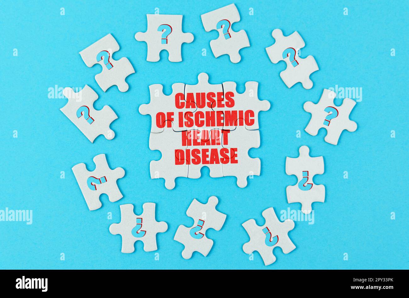 Concetto medico. Su una superficie blu sono puzzle con un punto interrogativo, al centro con l'iscrizione - cause di cardiopatia ischemica Foto Stock Concetto medico. Su una superficie blu sono puzzle con un punto interrogativo, al centro con l'iscrizione - cause di cardiopatia ischemica Foto Stock