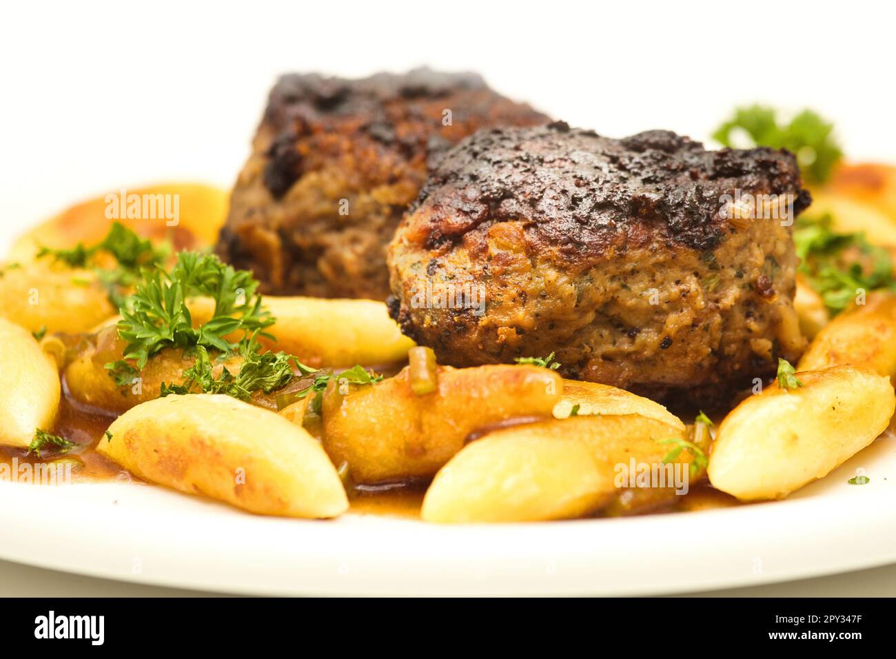 Deliziosa cucina casalinga: Polpette con tagliatelle di patate e prezzemolo in salsa sostanziosa Foto Stock