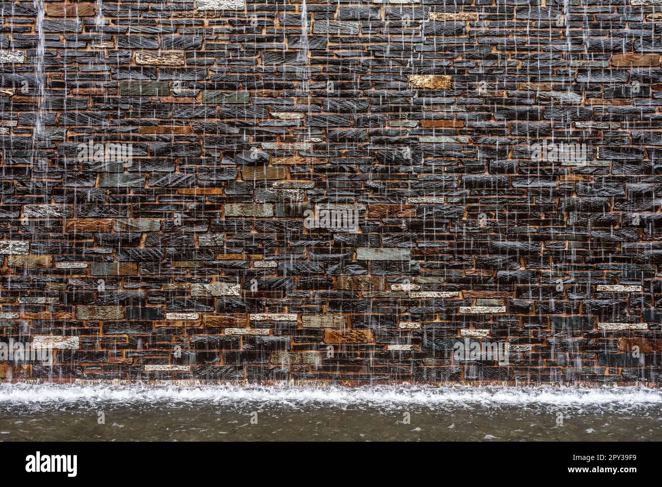 Muro di pietra e ruscello di acqua. Sfondo. Foto Stock