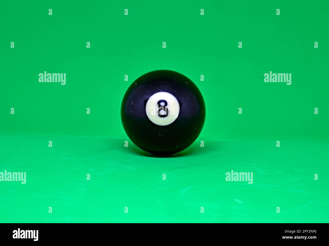 Primo piano di una palla da biliardo o da biliardo numero 8. Su sfondo verde come su un tavolo da biliardo. Foto Stock