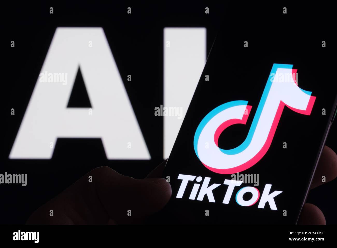 Logo TikTok visto sullo smartphone e lettere ai sullo sfondo. Concetto per l'intelligenza artificiale TikTok. Stafford, Regno Unito, 2 maggio 2023 Foto Stock