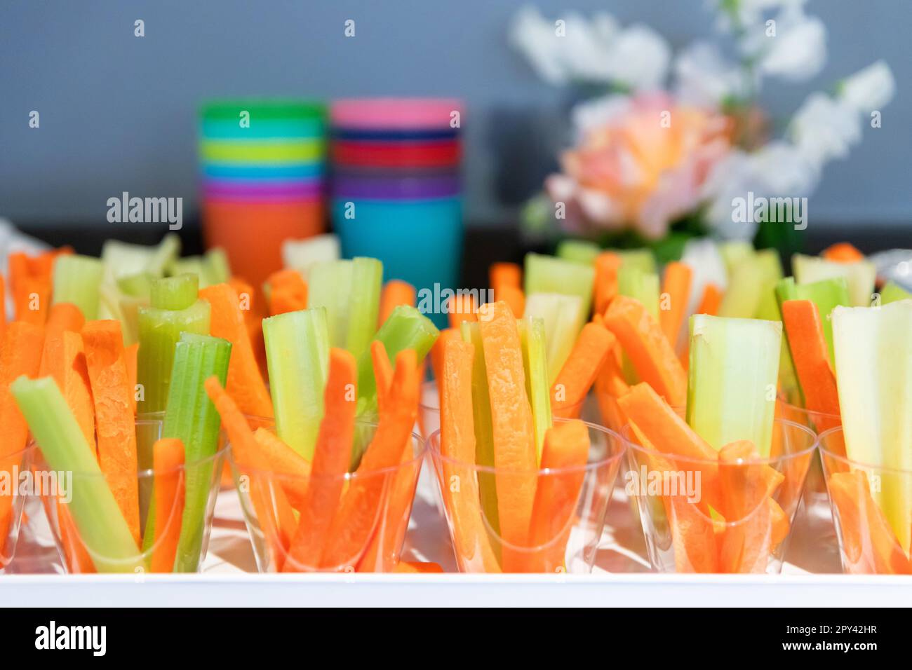 Bastoncini di carota e sedano in tazze trasparenti per bambini Foto Stock