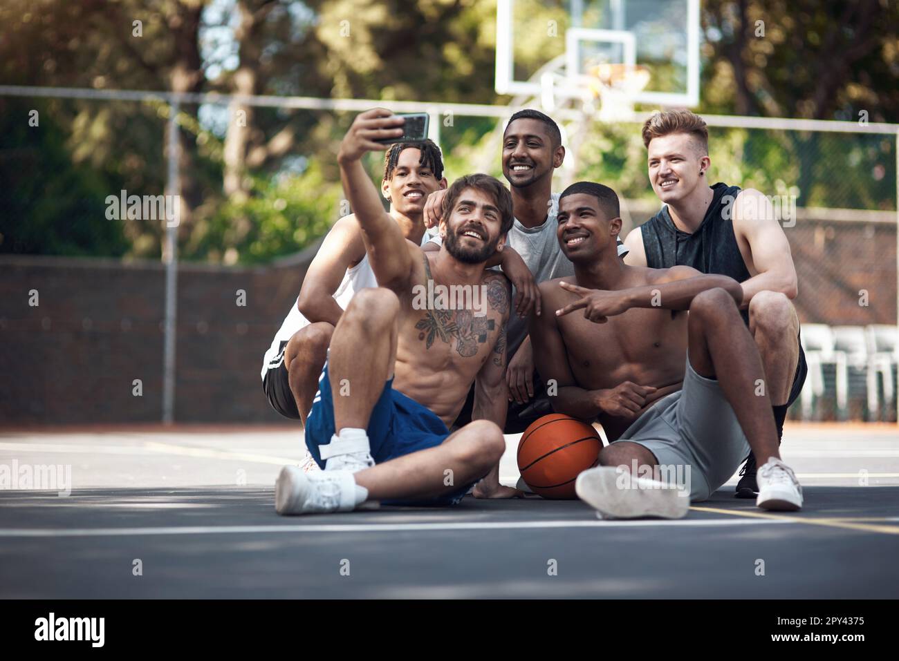 Solo un gruppo di amanti del basket. un gruppo di giovani sportivi che prendono selfie insieme su un campo sportivo. Foto Stock