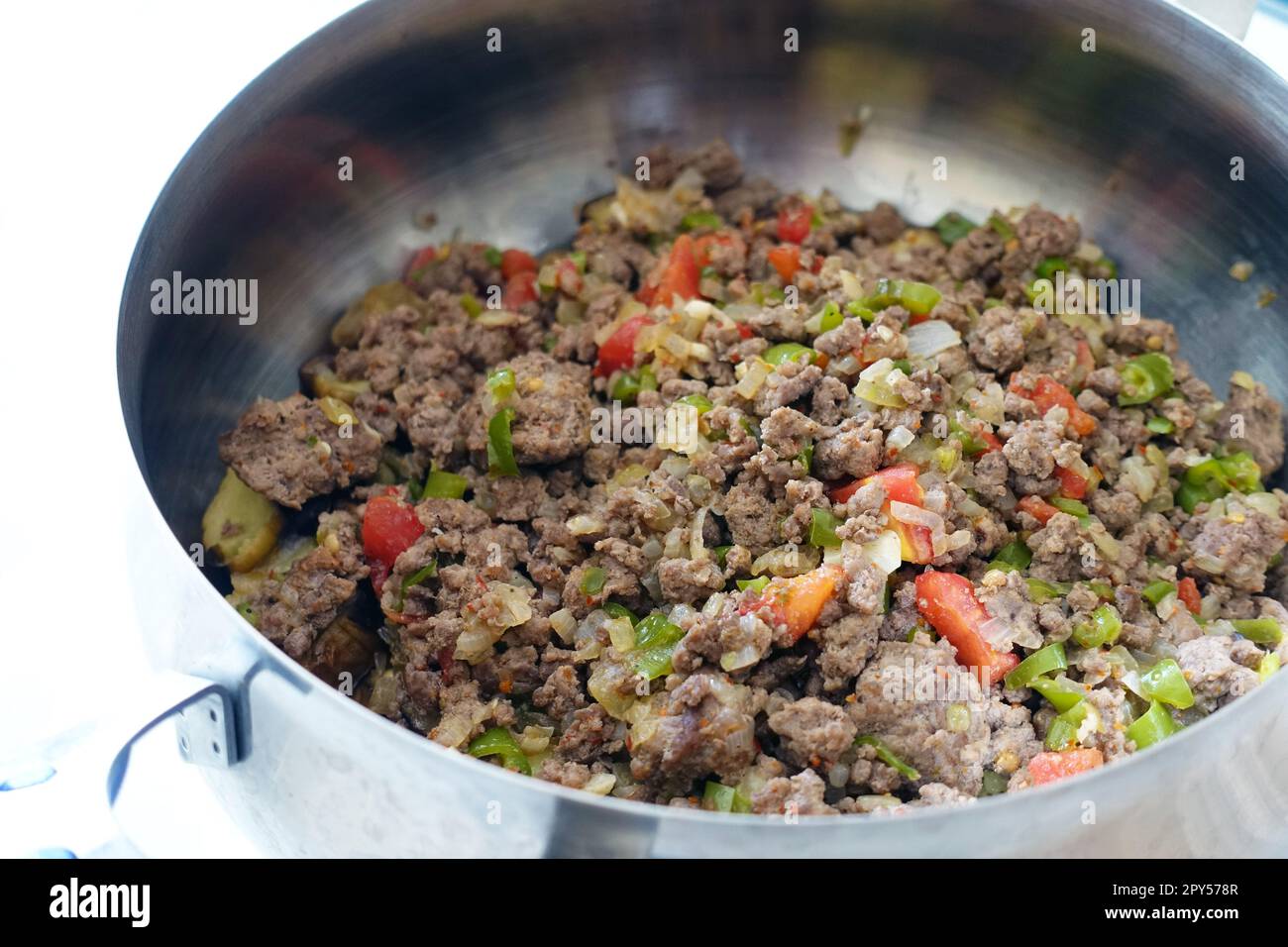 carne macinata di manzo con pomodori e cipolle in una pentola Foto Stock