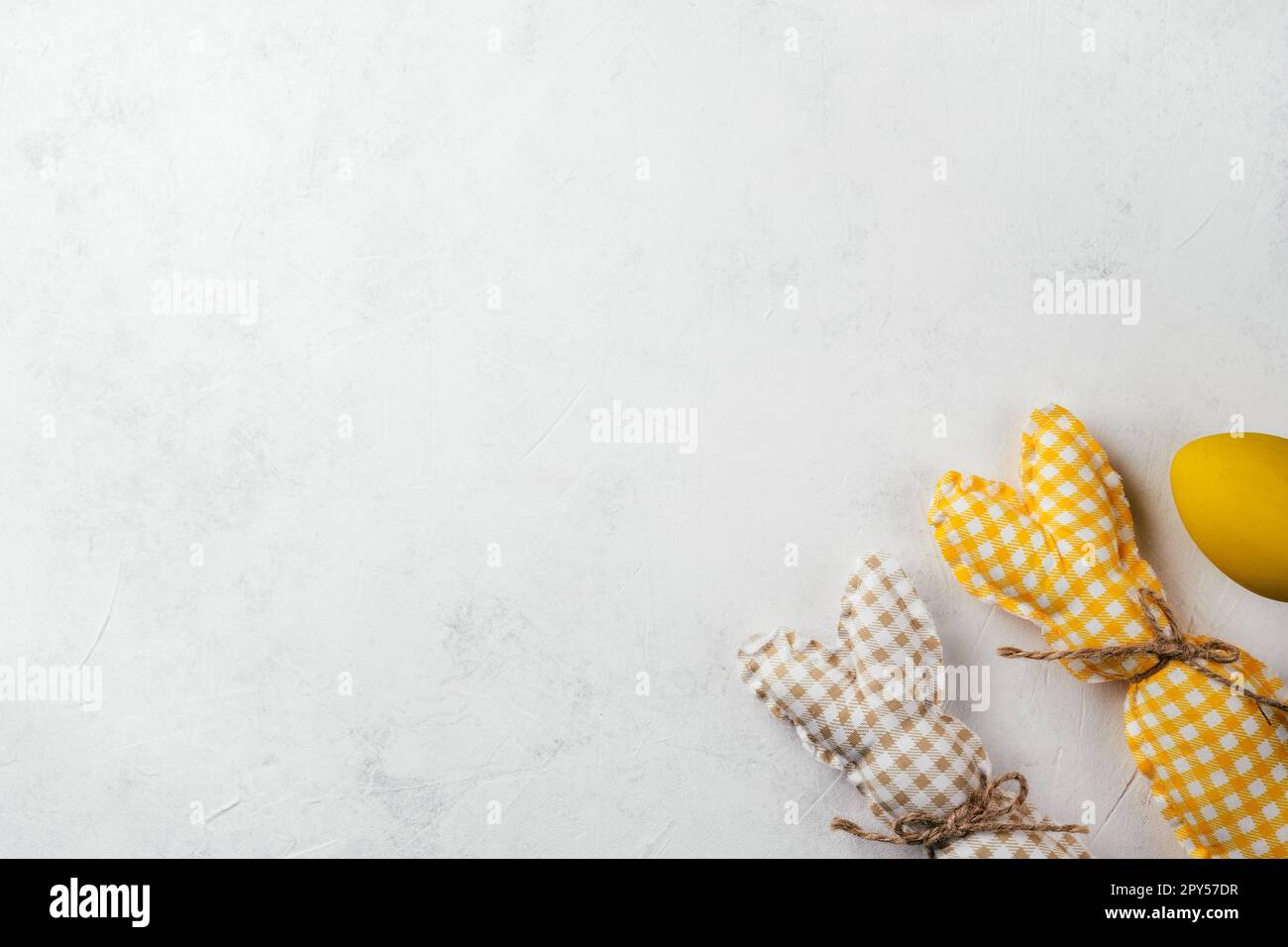 Cartolina di Pasqua per festeggiamenti, due coniglietti quadrati fatti a mano e uovo di gallina giallo su sfondo bianco Foto Stock