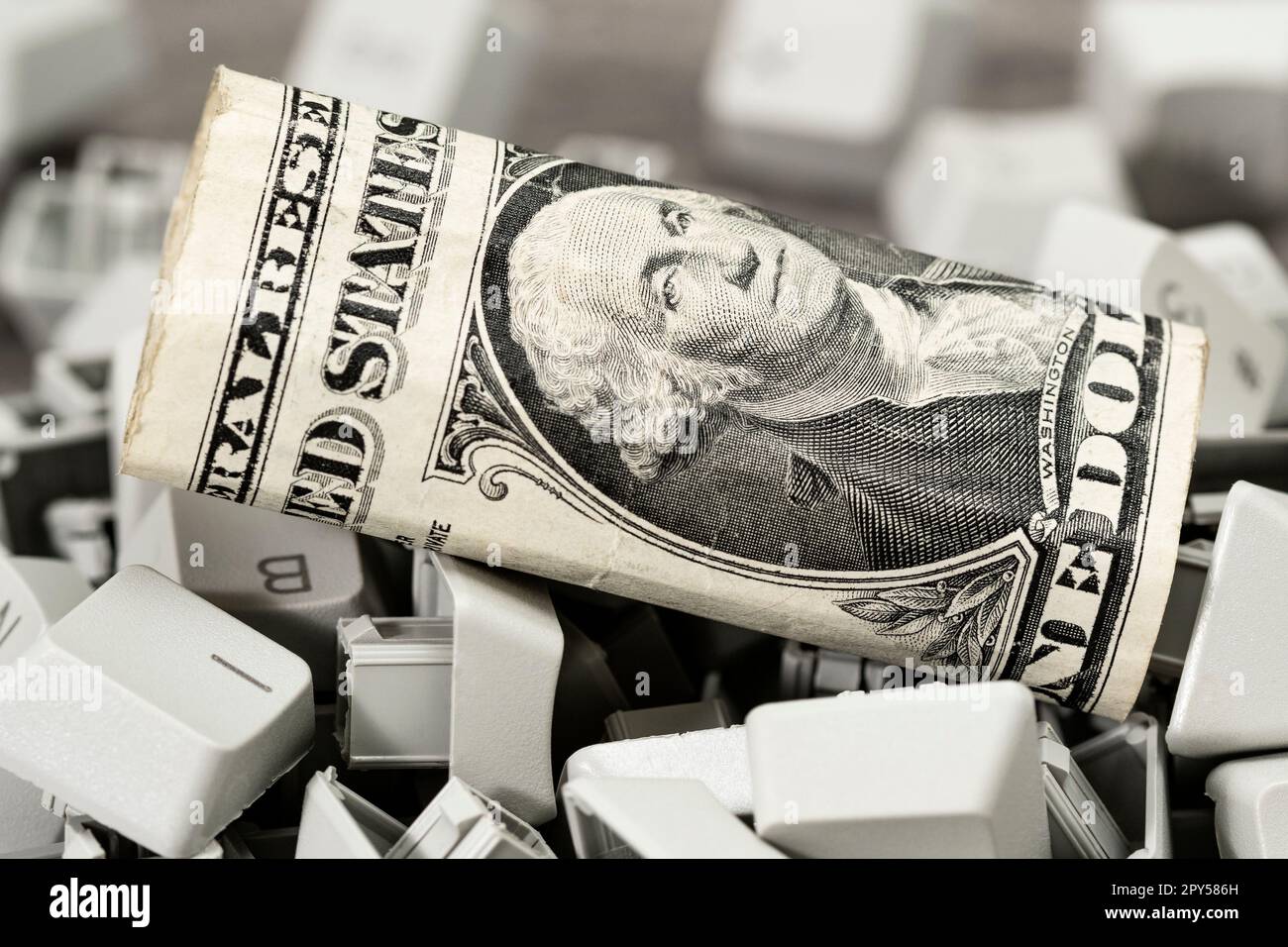 Una banconota da un dollaro sulla pila di tasti della tastiera del PC Foto Stock