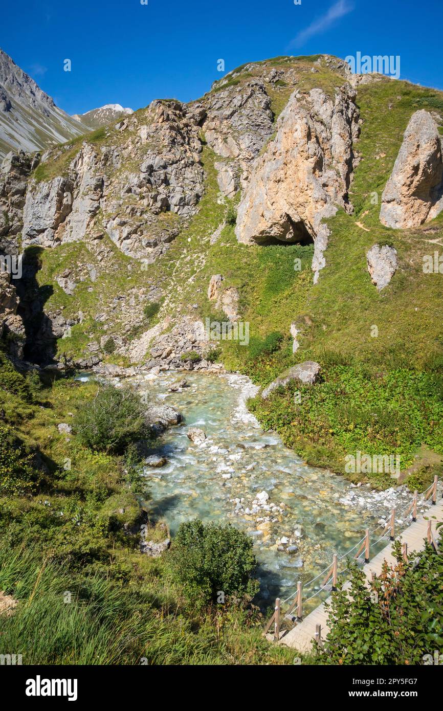 Fiume di montagna e ponte di legno nella valle del Parco Nazionale della Vanoise, alpi francesi Foto Stock
