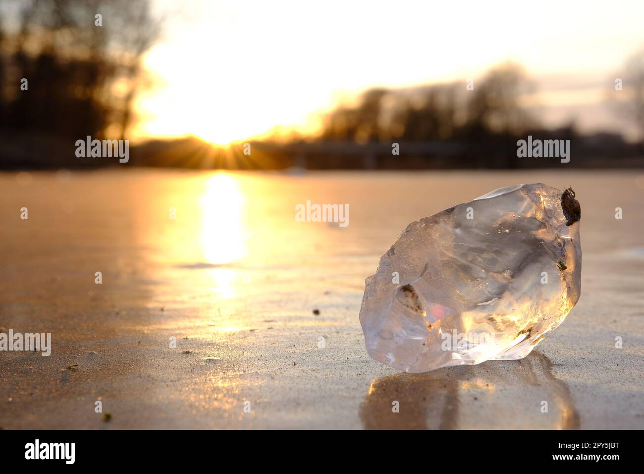 Primo piano di un pezzo di ghiaccio sul fiume congelato. Fiume in inverno. Luce del tramonto. Foto Stock