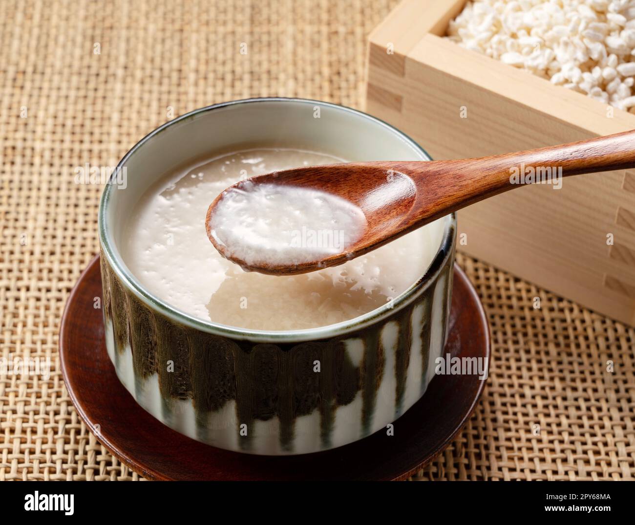 Amazake e un cucchiaio di legno sul tavolo. Foto Stock