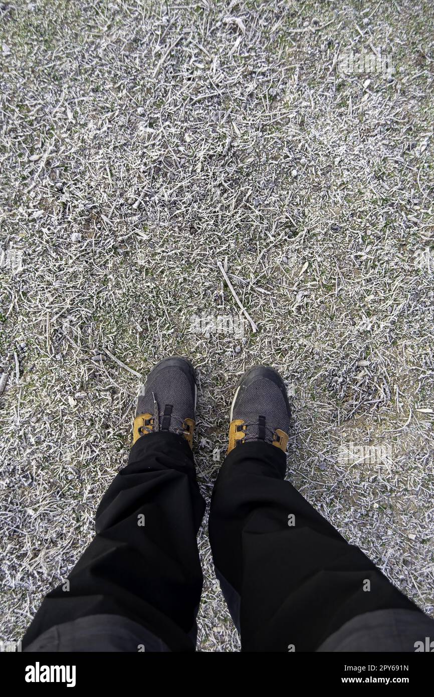 Piedi di uomo su un terreno ghiacciato Foto Stock