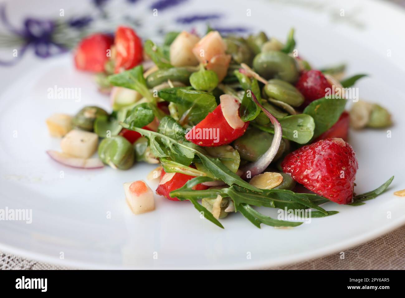 insalata con fragole e fave. Piatto delizioso in uno stile sano Foto Stock