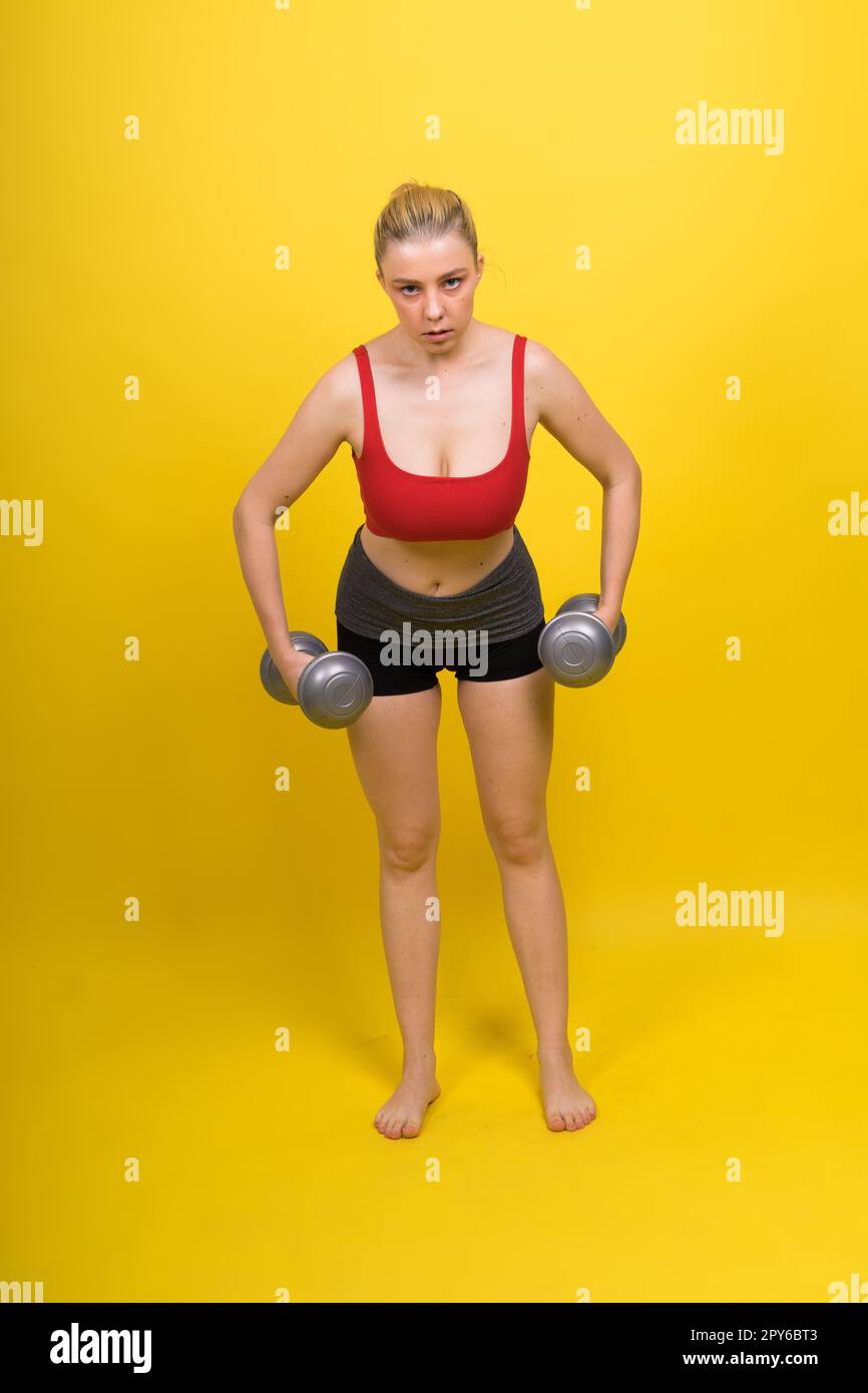 Forte sportivo in guanti da boxe preparati per il calcio alto. Isolato su sfondo bianco, rosso, giallo Foto Stock