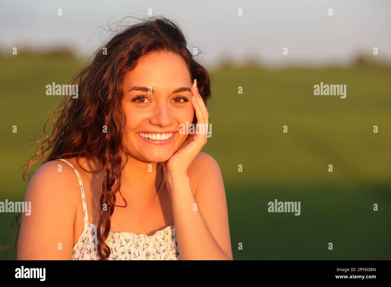 Bella donna felice che posa in un campo Foto Stock