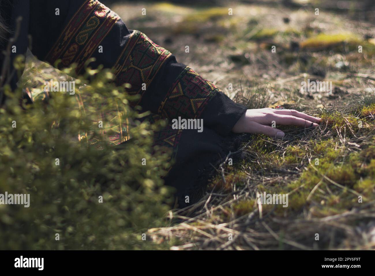 Primo piano mano femminile in abiti etnici toccando erba concetto foto Foto Stock