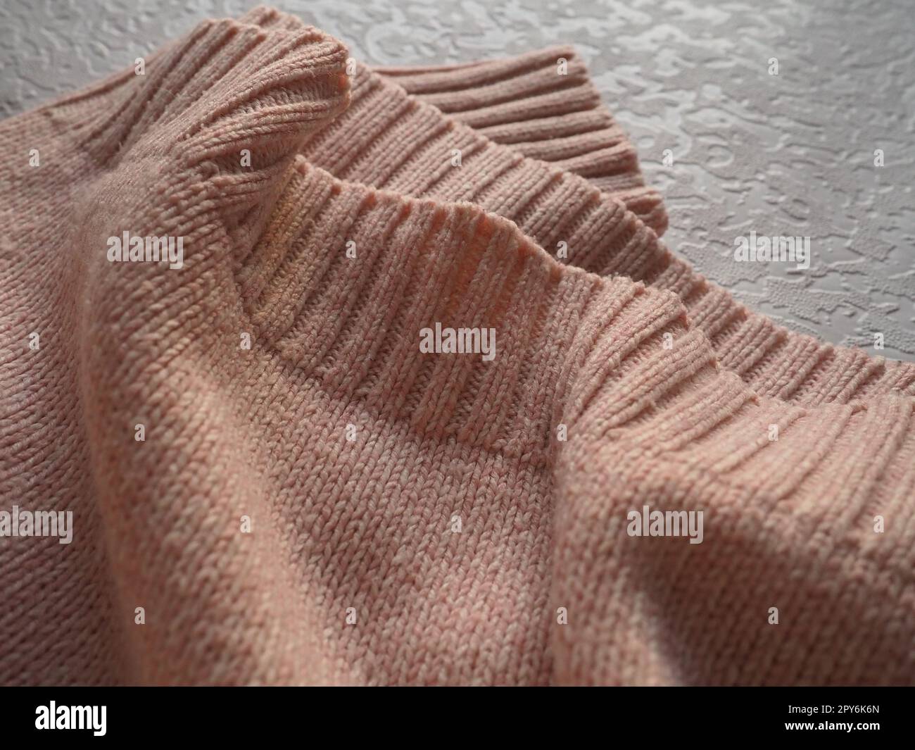 Maglieria a maglia. Maglione invernale caldo lavorato a maglia o maglione da vicino. Fili di lana o poliestere. Produzione di abbigliamento. La consistenza della maglia Foto Stock