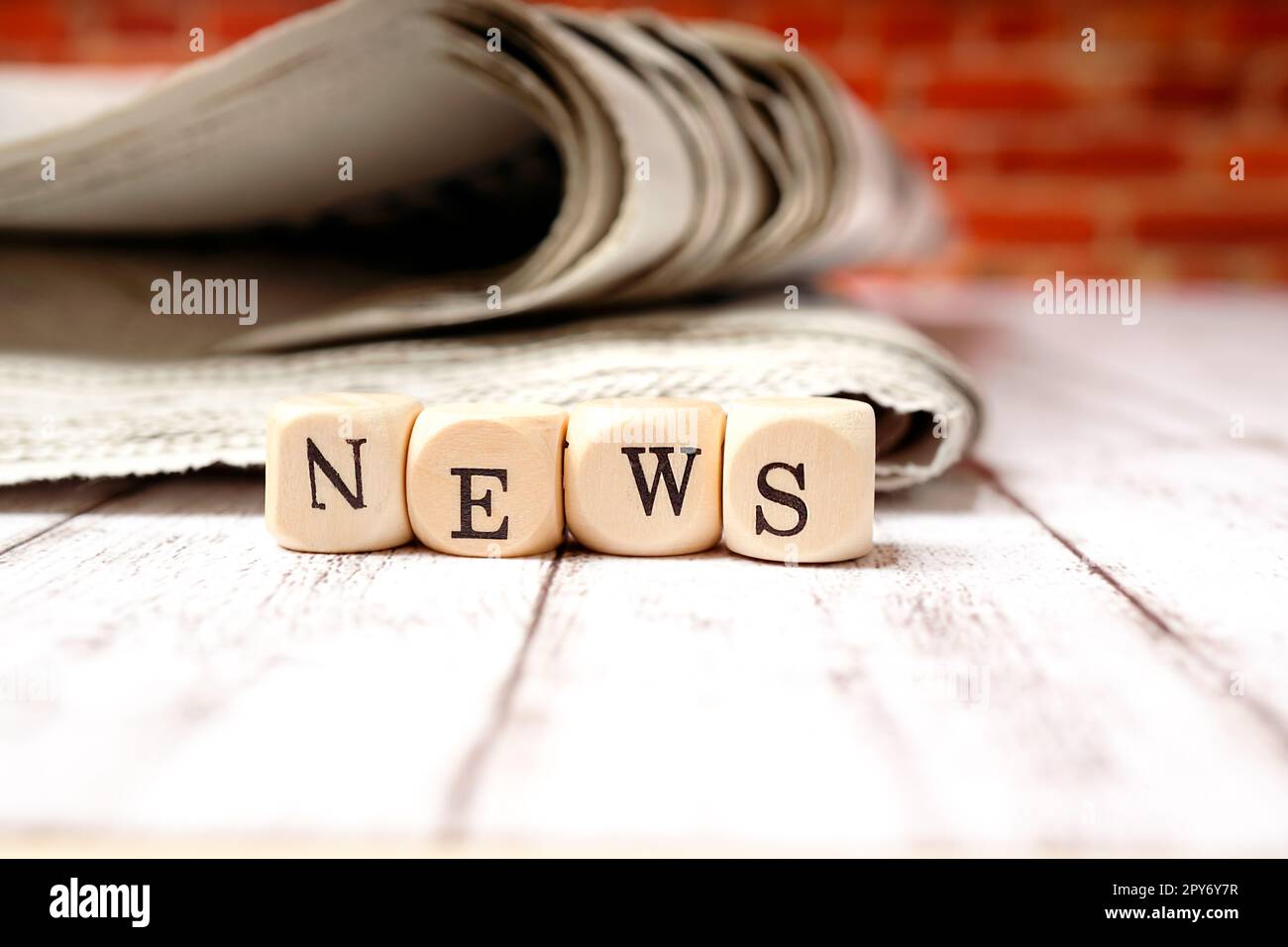 'News' - lettera di dadi e giornale su un tavolo Foto Stock