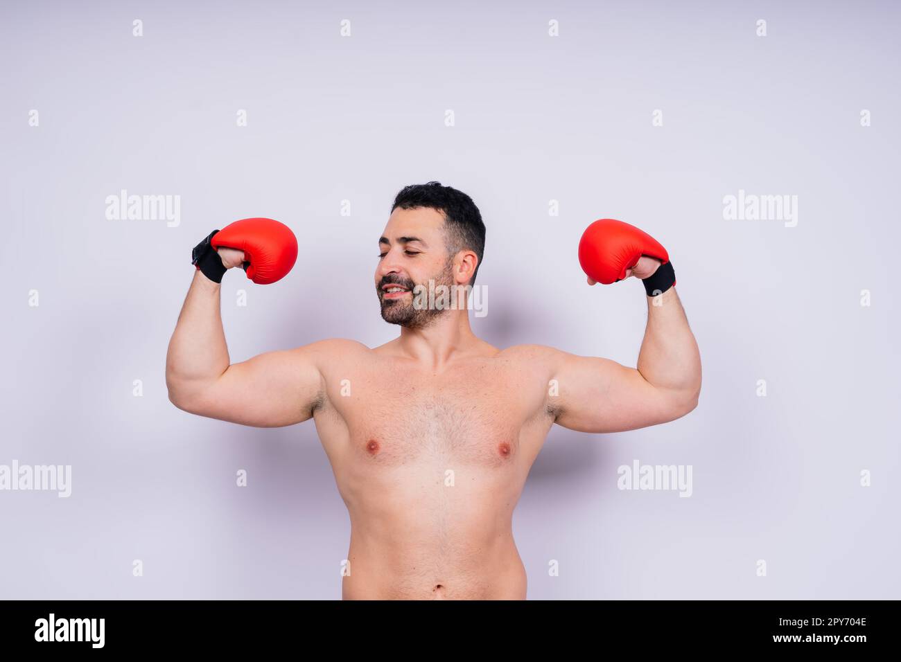 Giovane uomo caucasico bello isolato su sfondo bianco con guanti da boxe Foto Stock