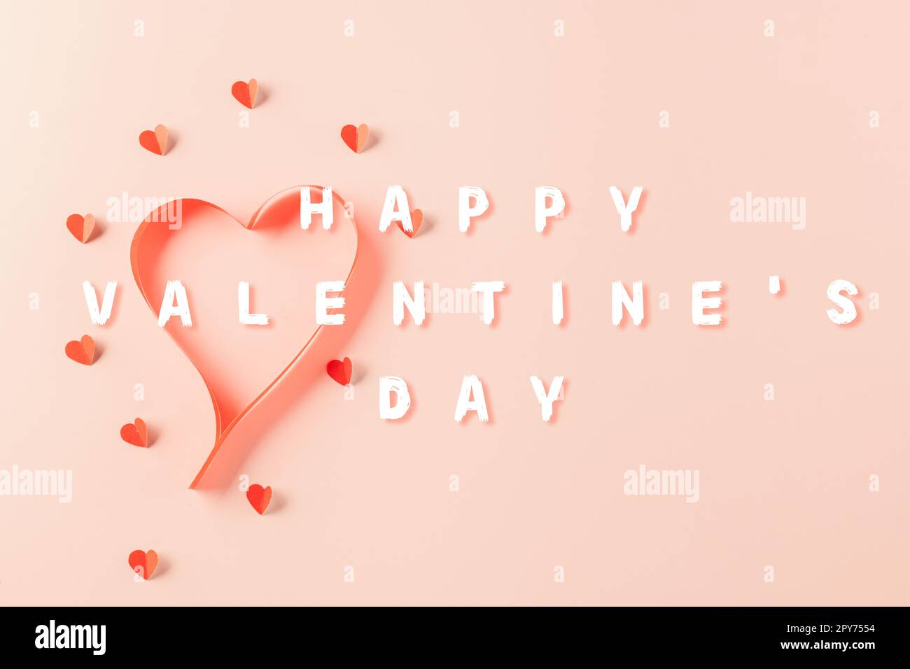 Vista dall'alto piatto di nastri a forma di cuore ed elementi di carta che tagliano cuori rossi che volano Foto Stock