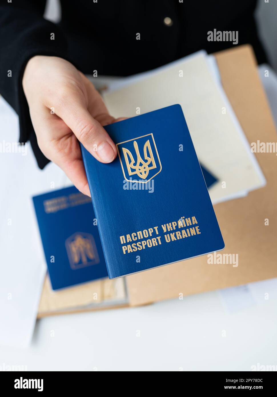 Leopoli, Ucraina - 23 gennaio 2023: Passaporto ucraino in mano sullo sfondo dei documenti. Passaporto di un cittadino ucraino. Iscrizione nel passaporto ucraino dell'Ucraina . Foto Stock