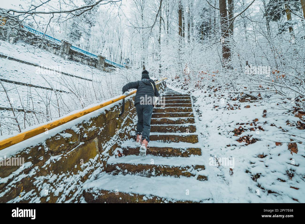 bambino su scale nel parco innevato di montagna Foto Stock