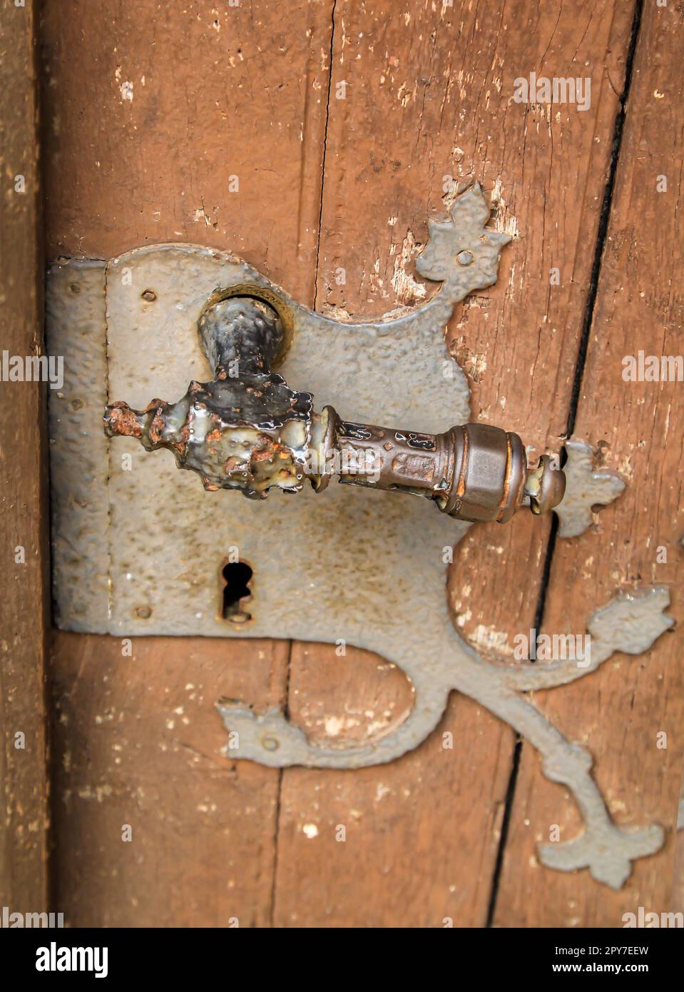 Una vecchia serratura con una maniglia della porta antica. Una porta di legno con una vecchia serratura. Foto Stock