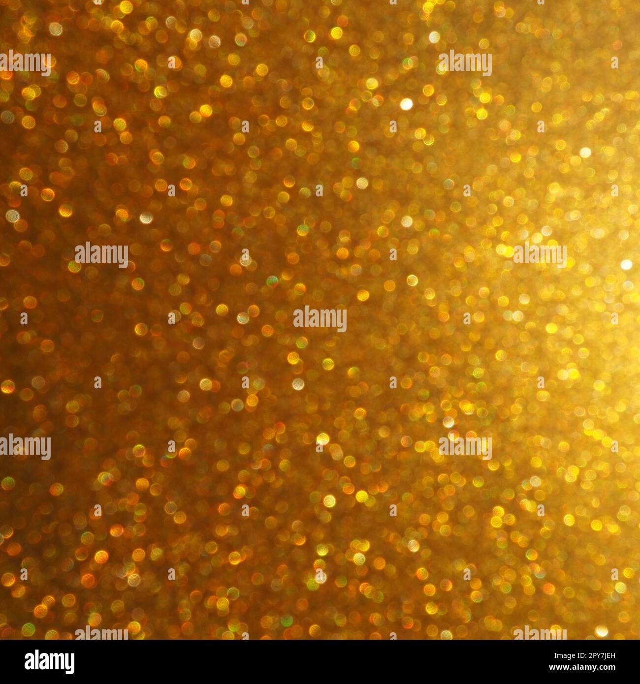 Luce bokeh di brillantezza dorata. Sfondo dorato con texture glitter. Carta da imballaggio glitter brillante con paillettes e scintillanti. Bokeh dorato e glitter festivi. Splendido sfondo. Foto Stock