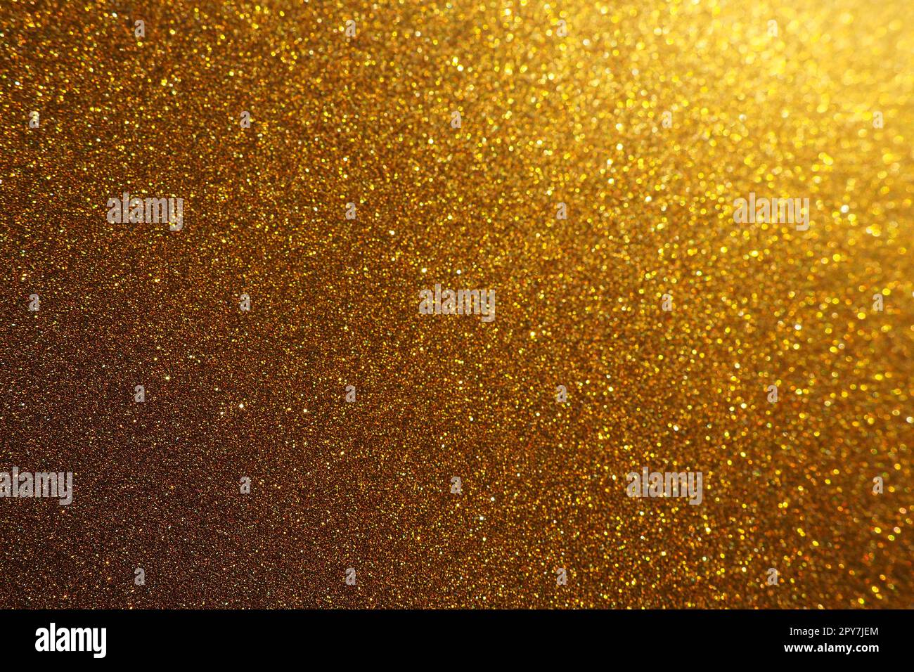 Luce bokeh di brillantezza dorata. Sfondo dorato con texture glitter. Carta da imballaggio glitter brillante con paillettes e scintillanti. Bokeh dorato e glitter festivi. Splendido sfondo. Foto Stock