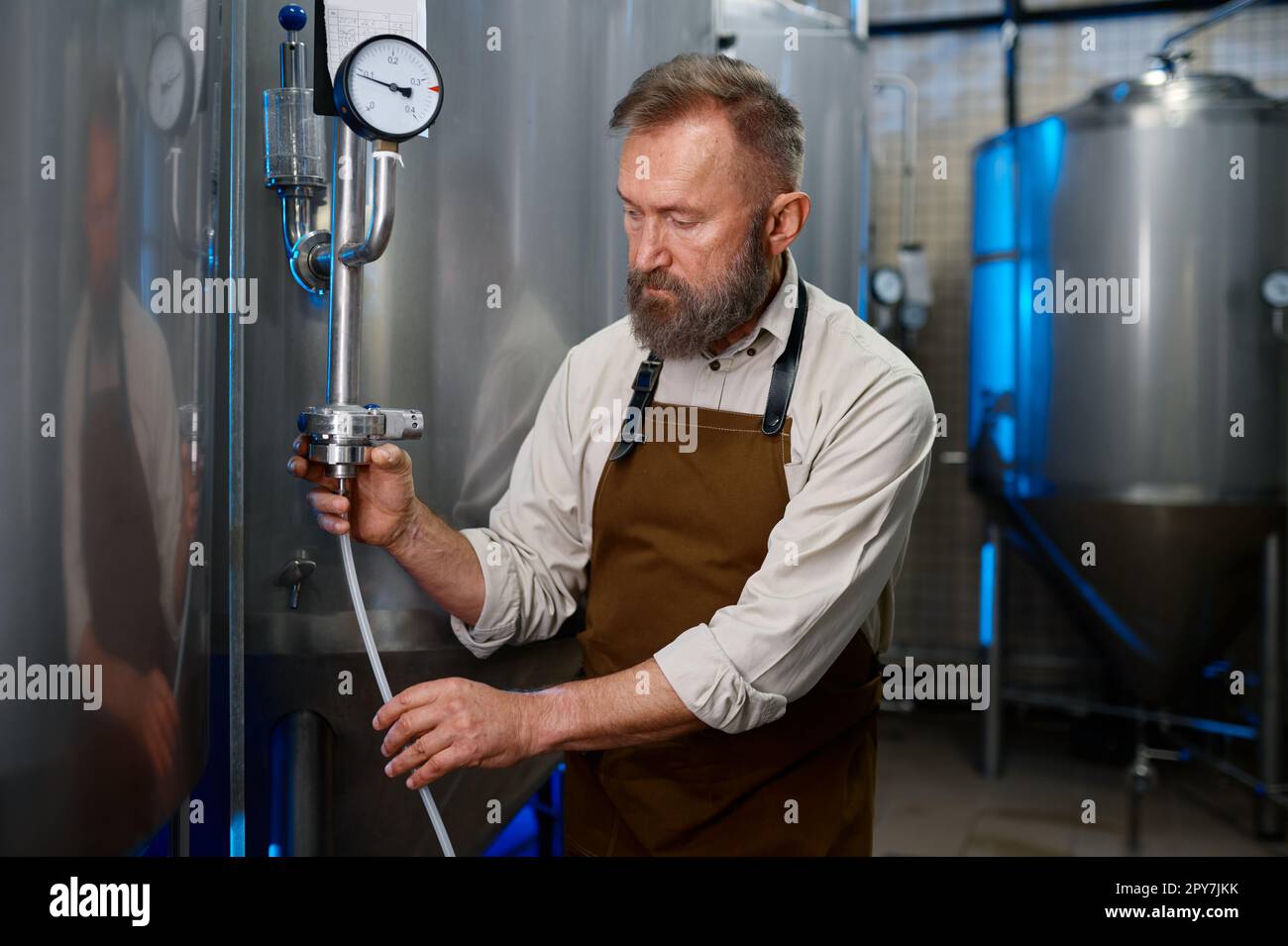 Uomo portatore adulto in officina di moderna fabbrica di birra industriale Foto Stock