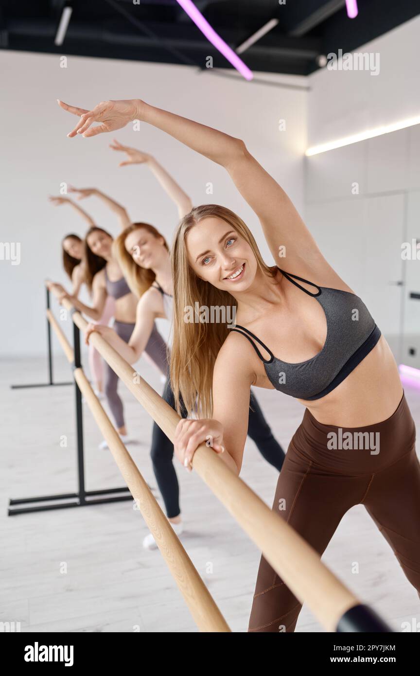 Giovani ballerine che allungano le gambe, praticando il movimento di balletto a barre Foto Stock