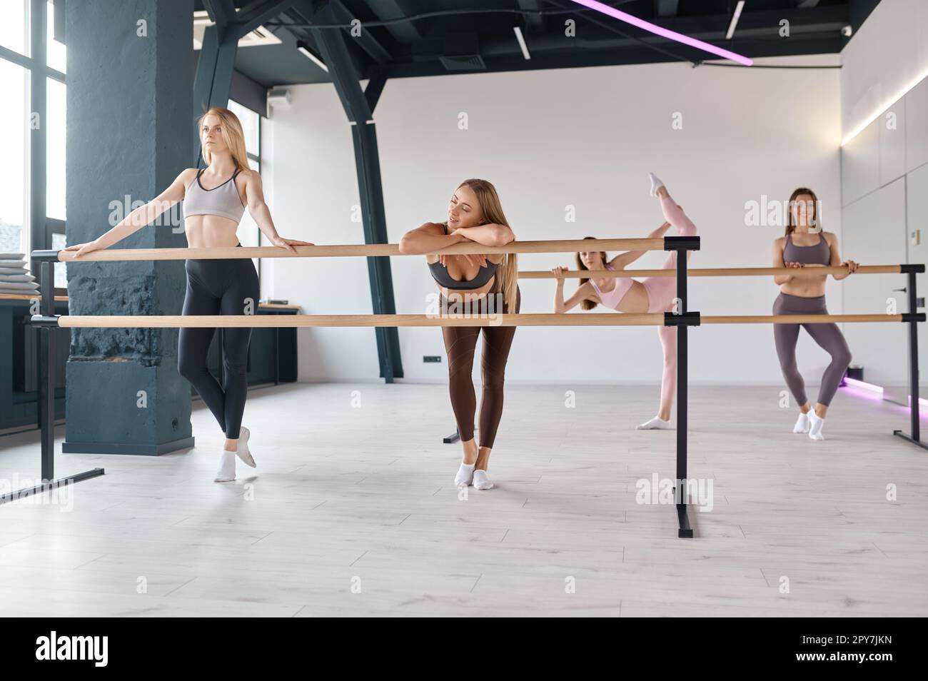 Giovani ballerine che allungano le gambe, praticando il movimento di balletto a barre Foto Stock