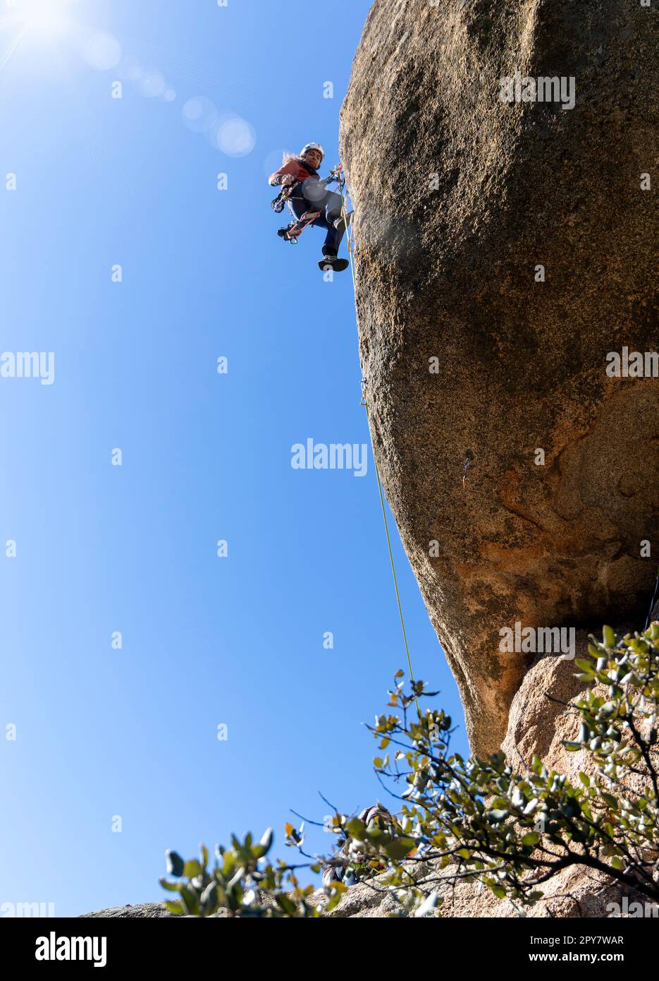 Giovane adulto che si arrampica su un muro di granito a Torrelodones, Madrid. Arrampicata su roccia. Concetto di sport estremi Foto Stock