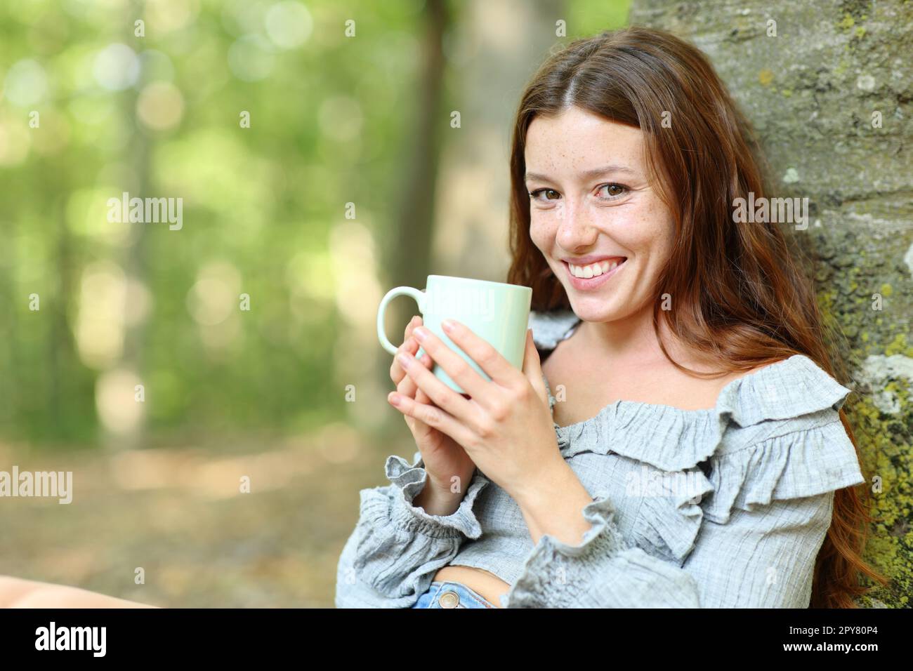 Happy Woman ti guarda tenendo fuori la tazza del caffè Foto Stock